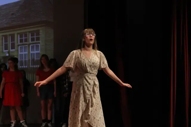 A student singing a solo in the spotlight